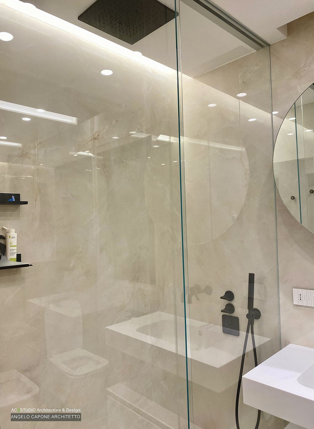 Luxurious bathroom with sleek marble walls, glass shower enclosure, and modern fixtures.