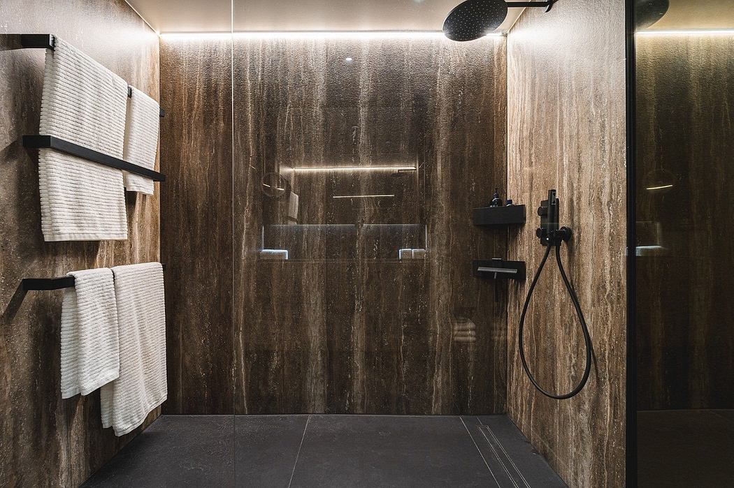 Modern bathroom with wood paneling and glass shower.