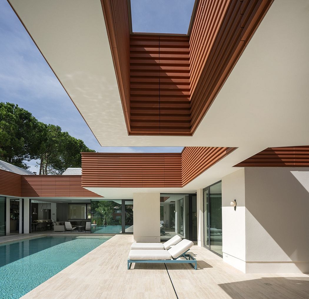 Elegant wooden ceiling details frame an outdoor pool area with lounge chairs.