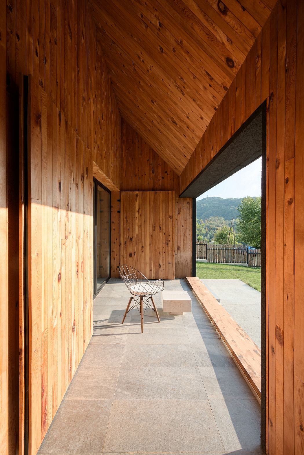 A cozy wooden interior with a patio and mountain view, showcasing clean architectural lines.