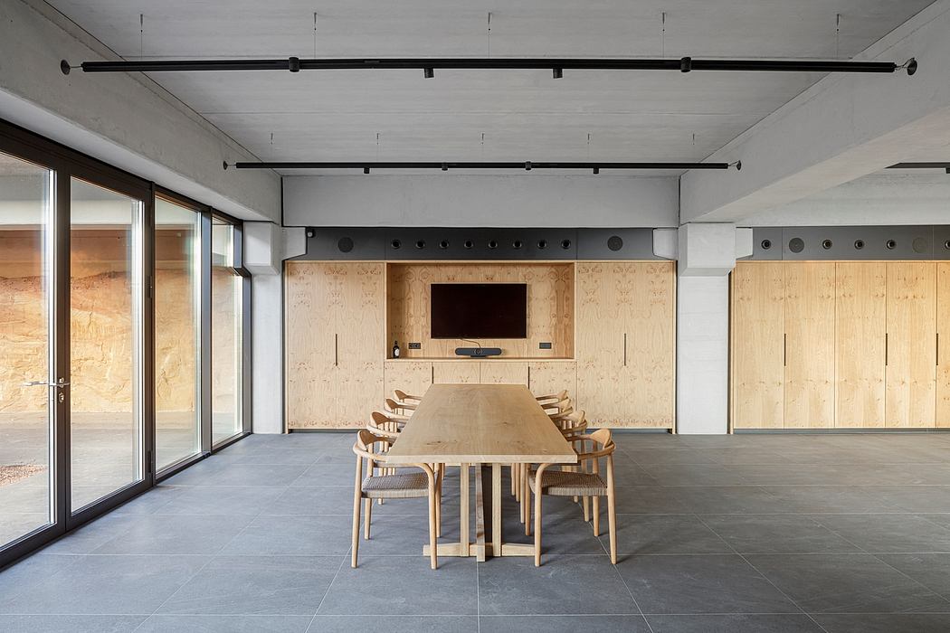 Minimalist conference room with long table, wooden panel walls, and floor-to-ce