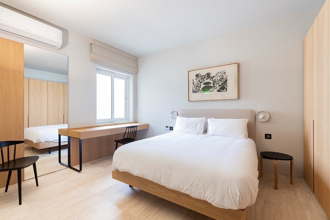 Minimalist bedroom with wooden furnishings, large window, and abstract artwork.
