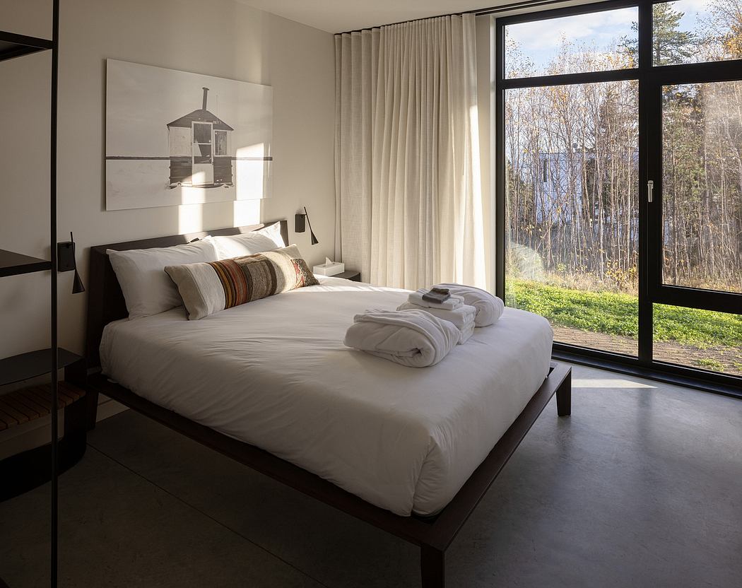 Minimalist bedroom with large window and neutral tones.