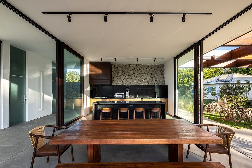 Contemporary dining area with glass walls and stone accent kitchen wall.