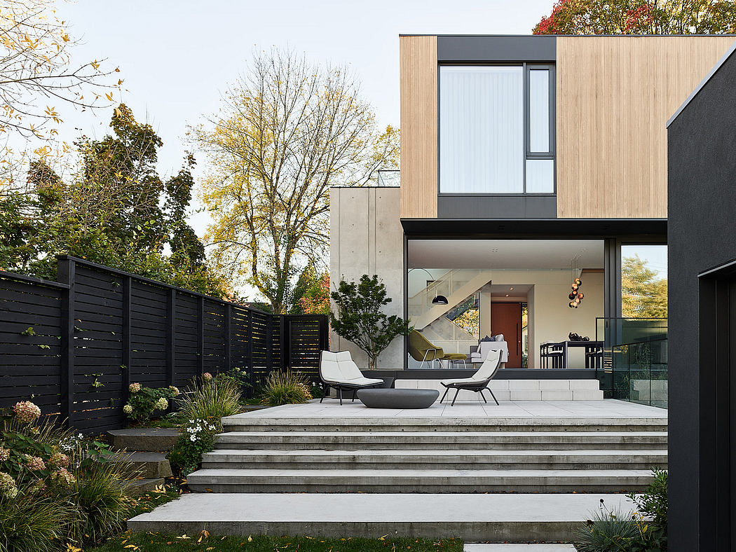 Modern home exterior with wooden accents and outdoor seating.