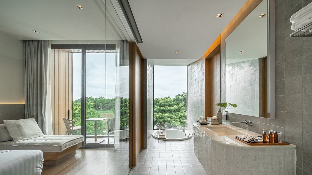 Modern bathroom with freestanding tub by a glass wall overlooking greenery.