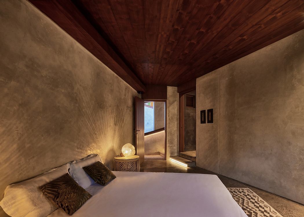 Warm-toned room with rustic wooden ceiling, textured walls, and a cozy bed setup.