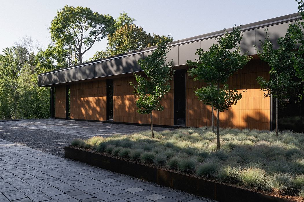 A modern building with a wooden facade, surrounded by lush greenery and landscaping.