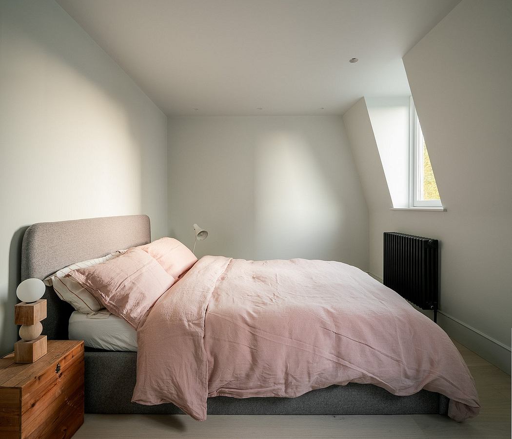 Minimalist bedroom with slanted ceiling and natural light.