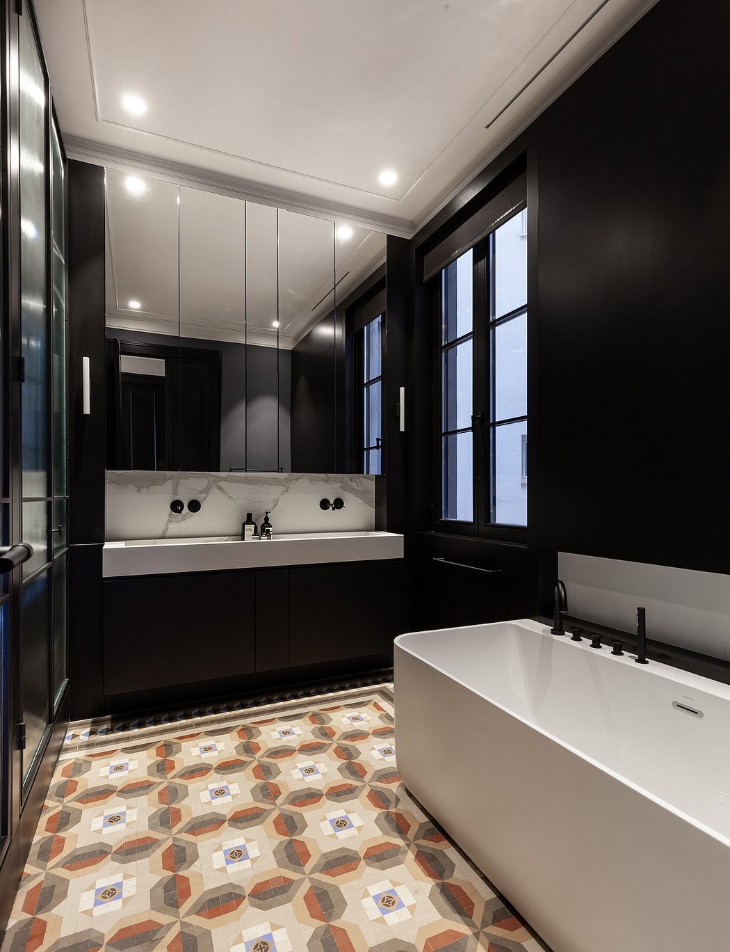 Modern bathroom with black walls, white fixtures, and patterned floor tiles.