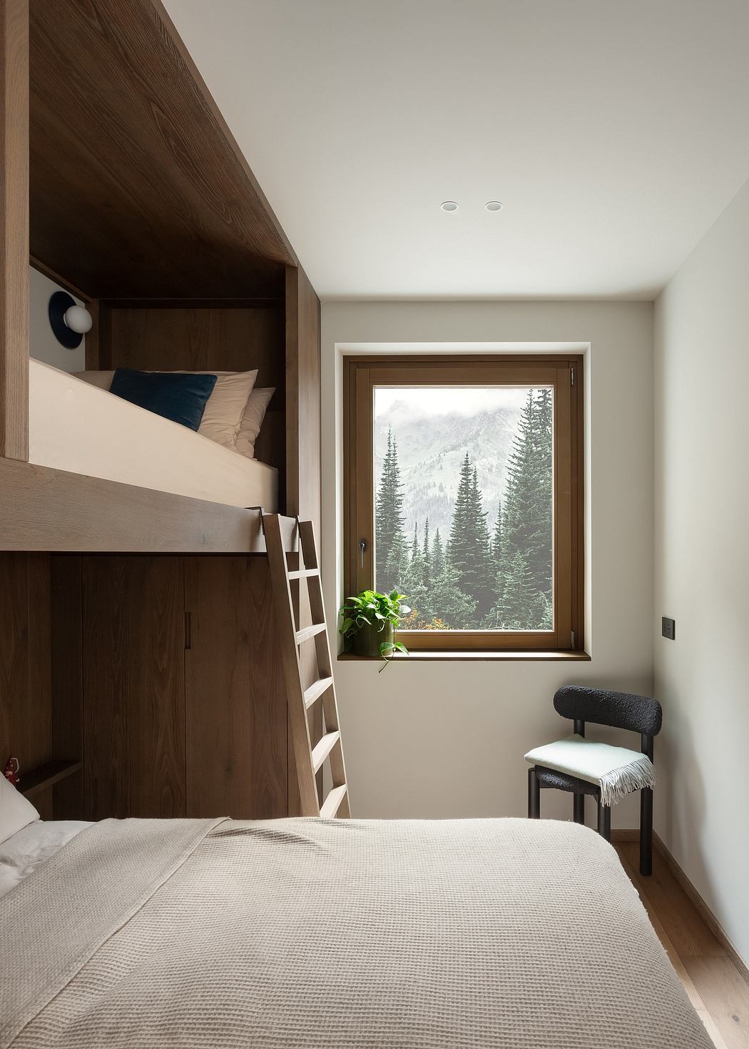 Contemporary bedroom with lofted bed, wooden details, and scenic forest view through
