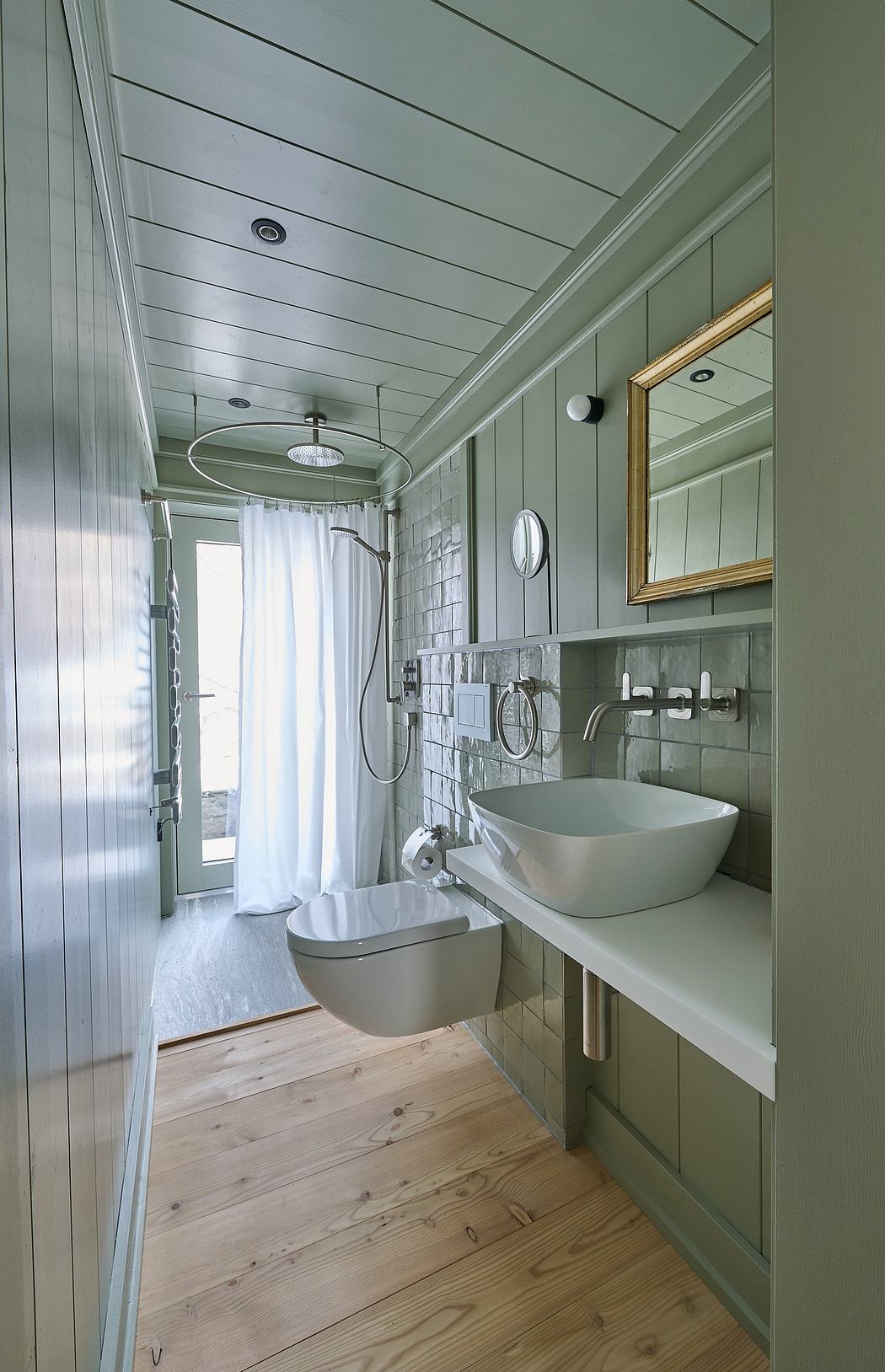 Narrow bathroom with wooden floors and green walls