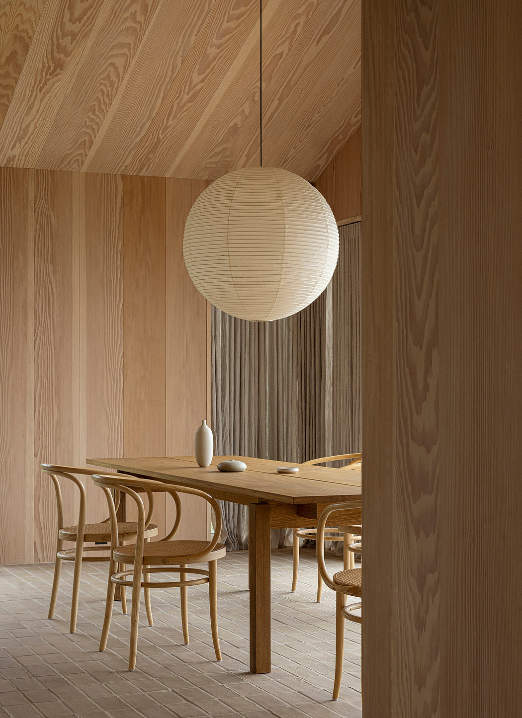 Wood-paneled dining area with spherical pendant light.