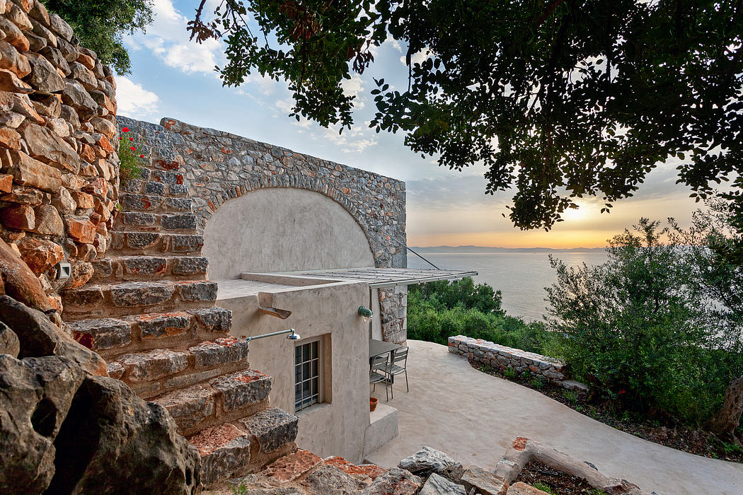 An arched entrance leads to a secluded outdoor patio with a scenic sea view.