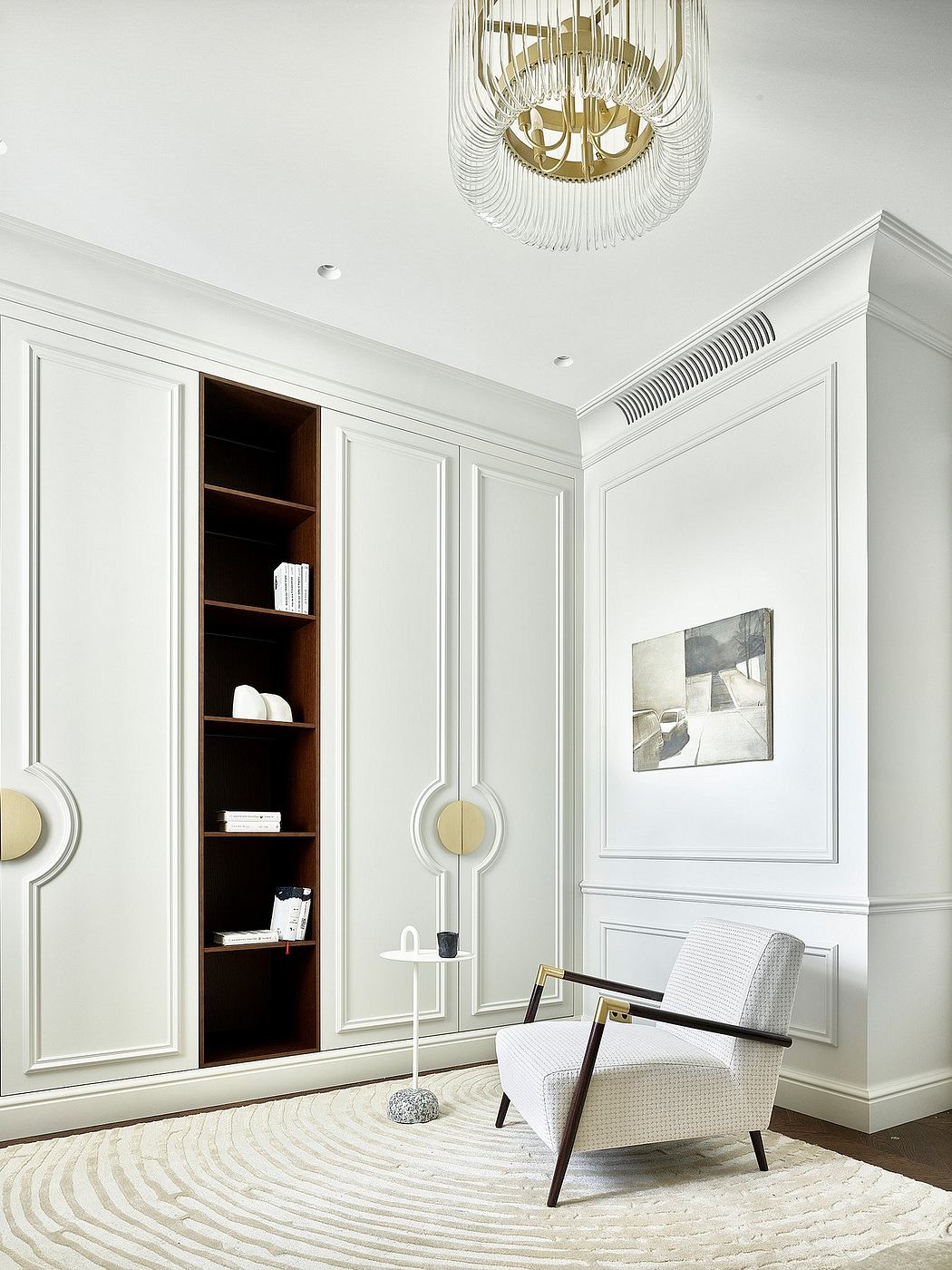 Elegant room with white wainscoting, modern chandelier, and built-in shelving.