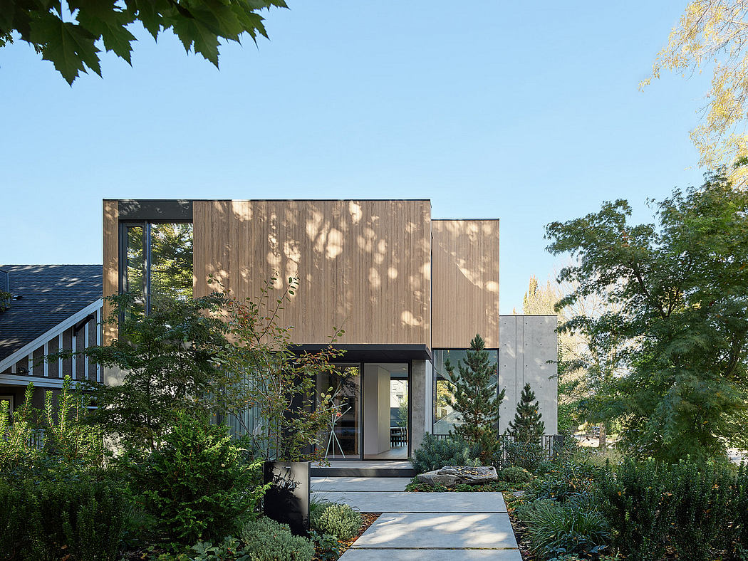 Modern house with wooden facade surrounded by greenery.