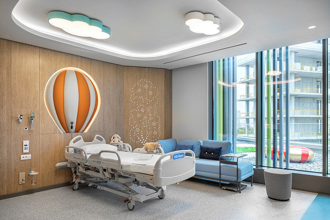 Bright pediatric hospital room with a hot air balloon theme and modern furnishings.