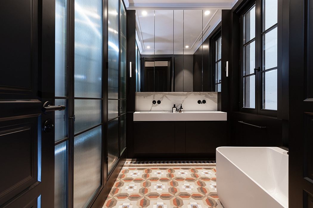 Contemporary bathroom with dark cabinets, patterned floor tiles, and white fixtures.