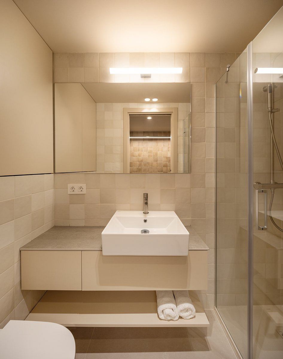 Minimalist bathroom with clean lines, recessed lighting, and a wall-mounted vanity.