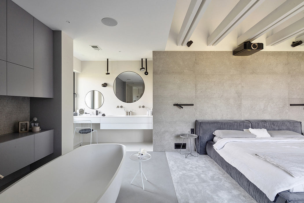 Modern open-plan bedroom with integrated bathroom, minimalist decor, and neutral tones.