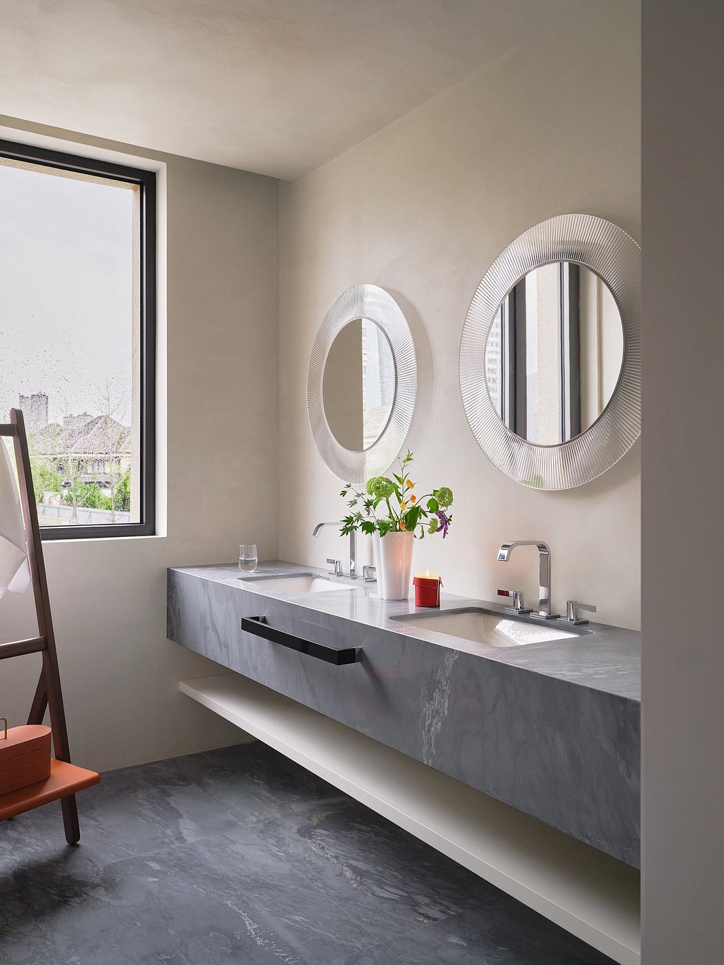 A modern bathroom with minimalist vanity, round mirrors, and potted plants by the window.