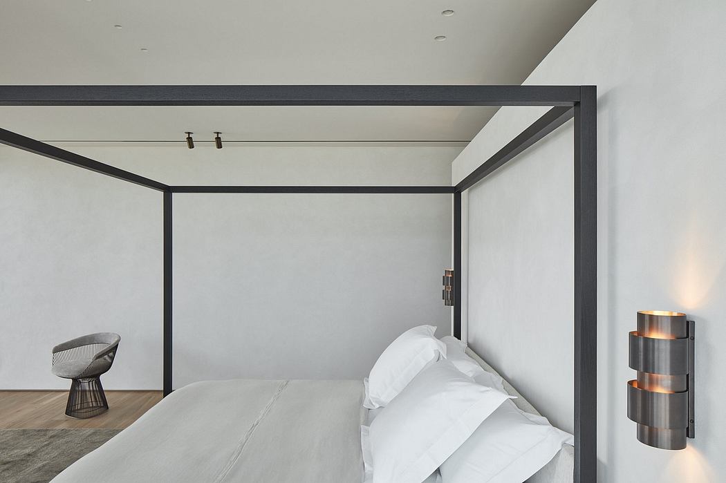 Minimalist bedroom with sleek black metal frame, white bedding, and accent lighting.