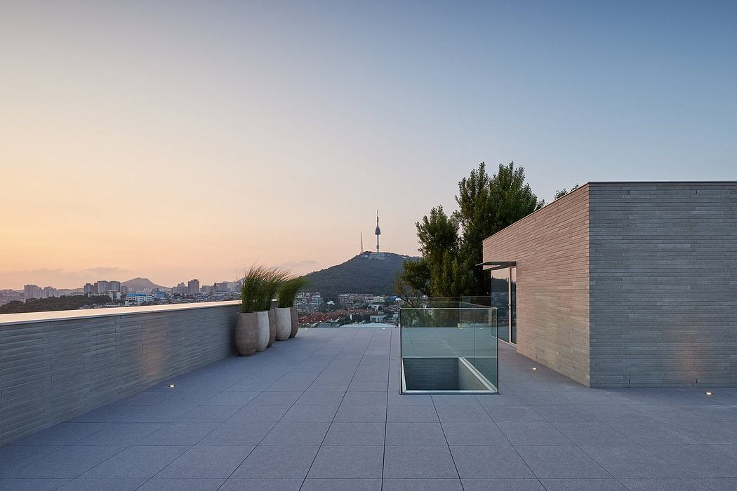 Minimalist rooftop terrace with cityscape view at dusk.