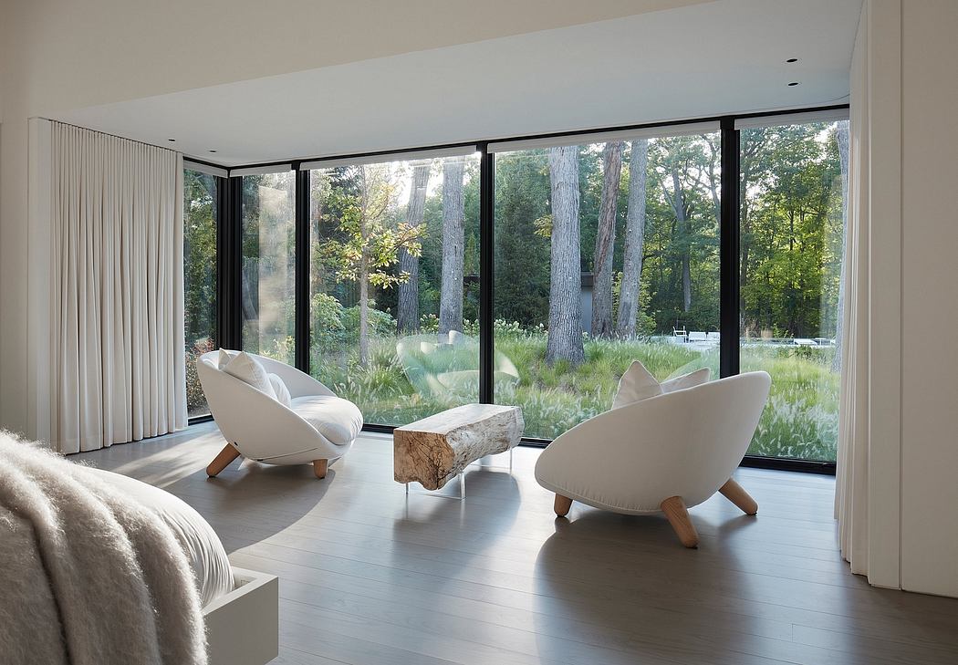 Contemporary room with floor-to-ceiling windows overlooking nature.