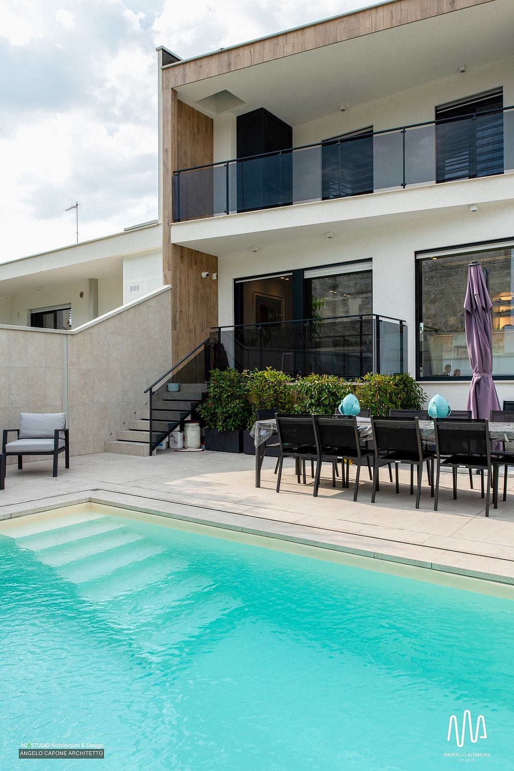 Modern, minimalist exterior with wood and glass details, pool, and outdoor dining area.