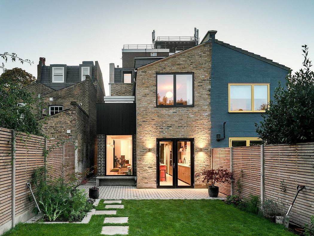 Contemporary house with a brick facade and backyard garden at dusk.