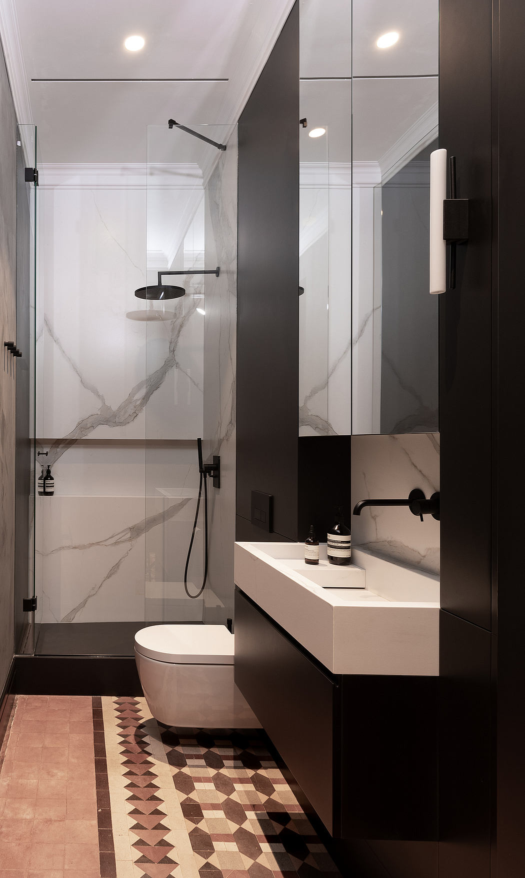 Contemporary bathroom with patterned floor and glass shower enclosure.