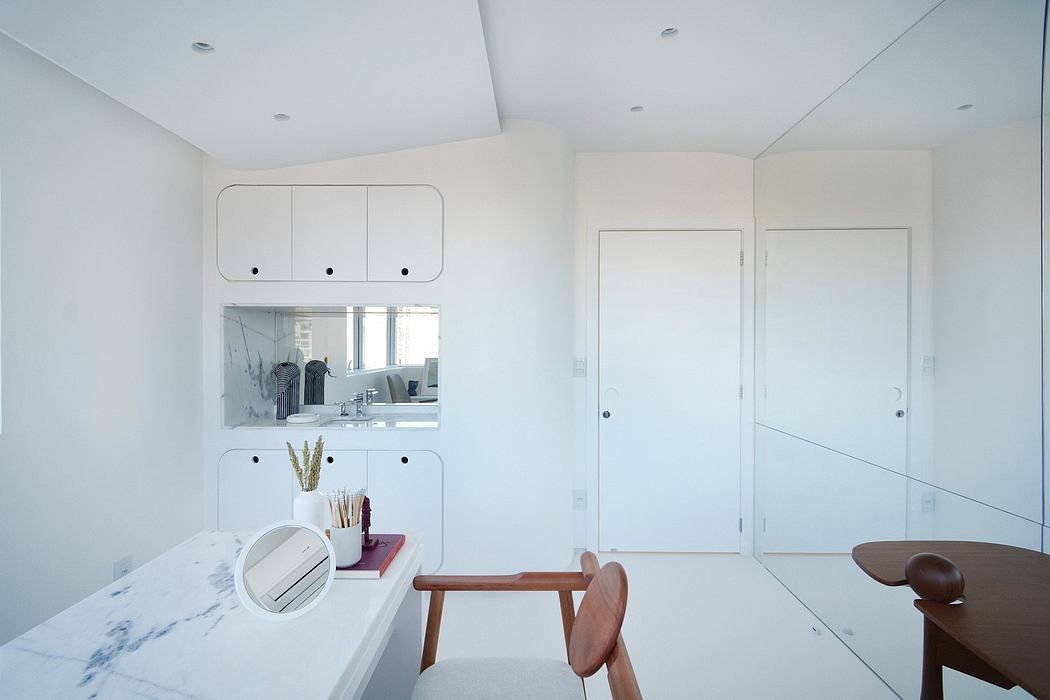 A minimalist, light-filled room with integrated storage, wooden furniture, and clean lines.