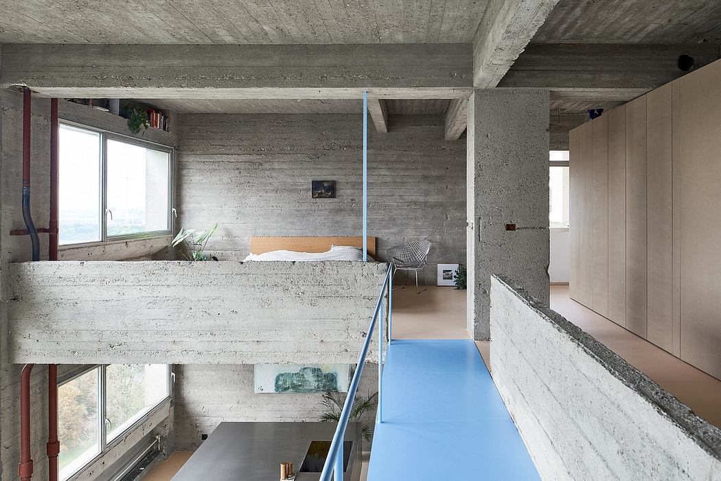 Minimalist interior with exposed concrete and a blue floor.