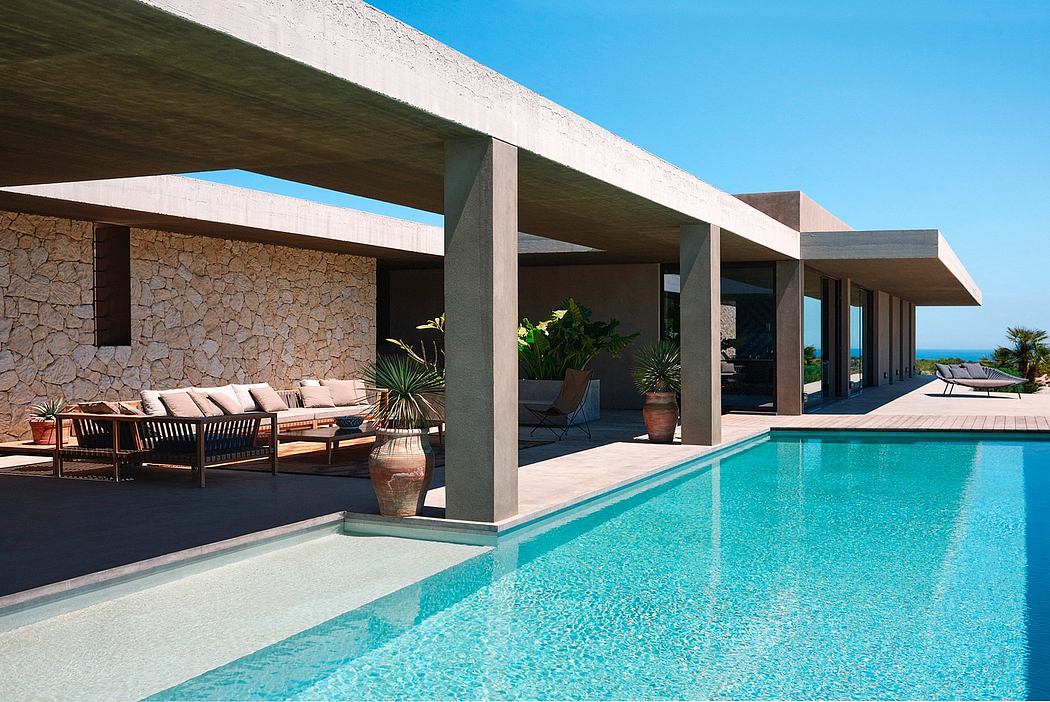 Sleek villa with poolside terrace and ocean view.