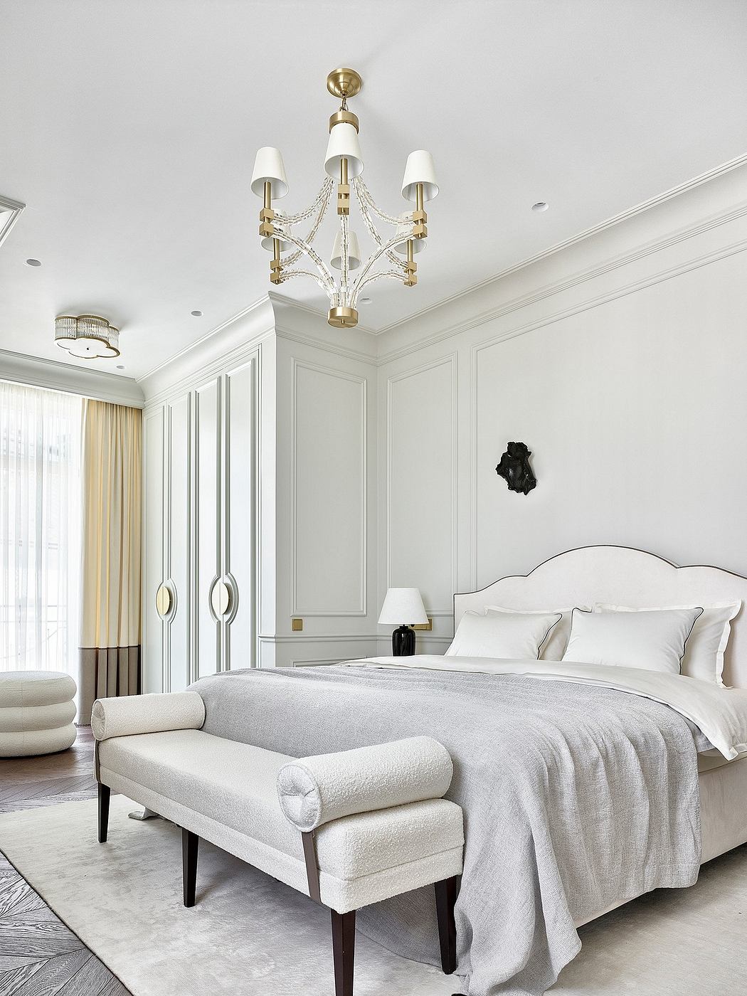 Elegant bedroom with refined architectural details, plush furnishings, and a luxurious chandelier.