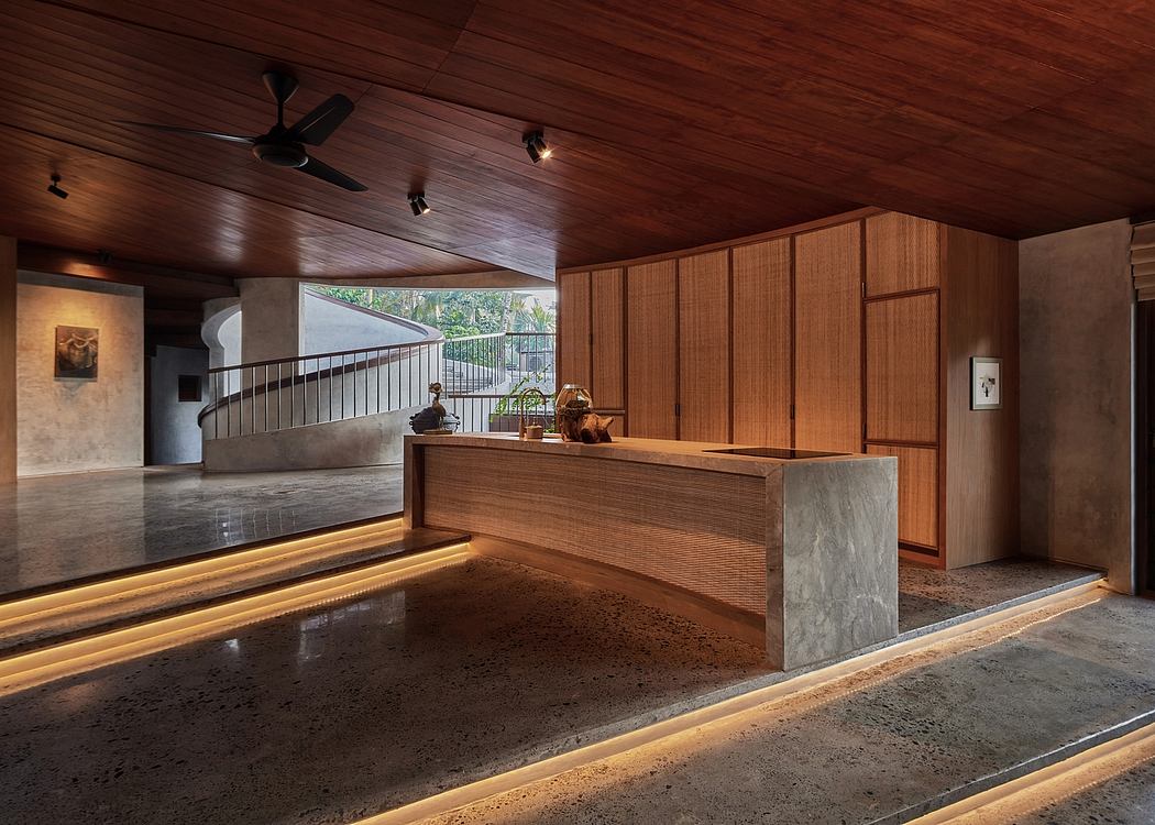 Warm, wooden lobby with recessed lighting, stone counter, and window overlooking greenery.