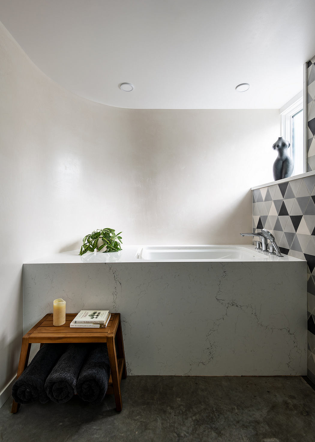 Modern bathroom with sleek marble countertop, recessed lighting, and minimalist decor.