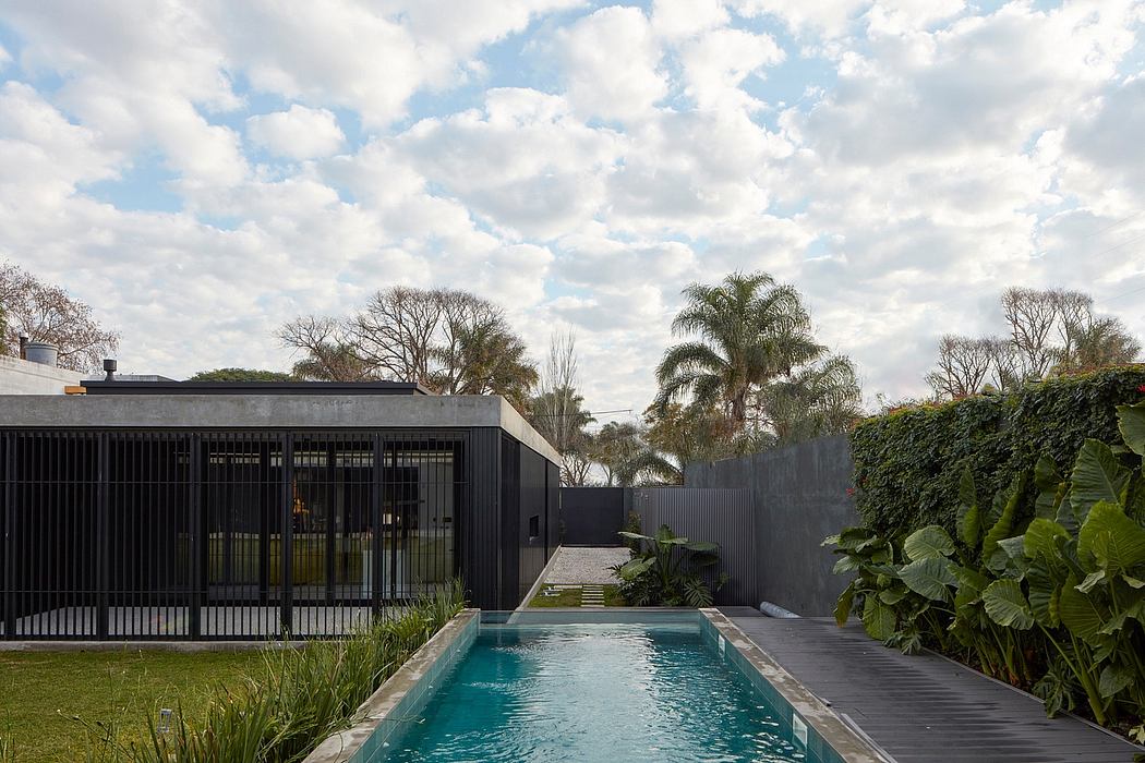 Contemporary poolside with sleek design and lush greenery.