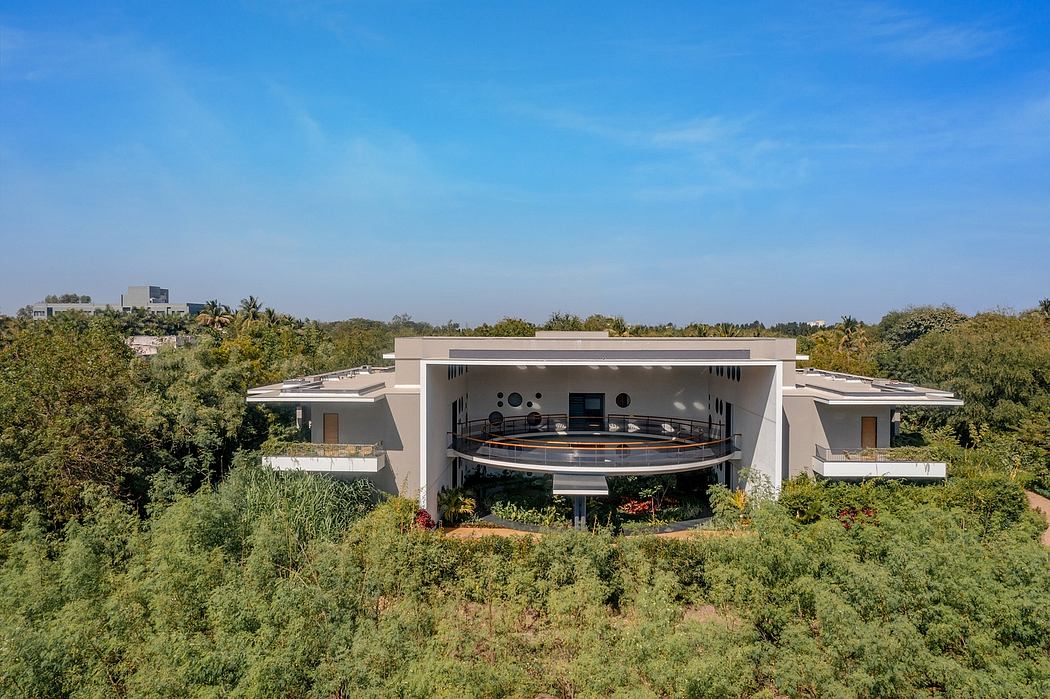 A modern, multi-level residential building surrounded by lush greenery with a circular balcony.