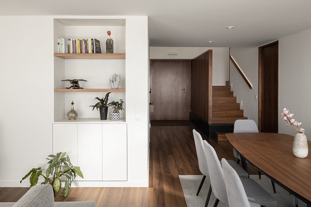 Minimalist dining area with built-in shelving, wood floors, and modern furniture.