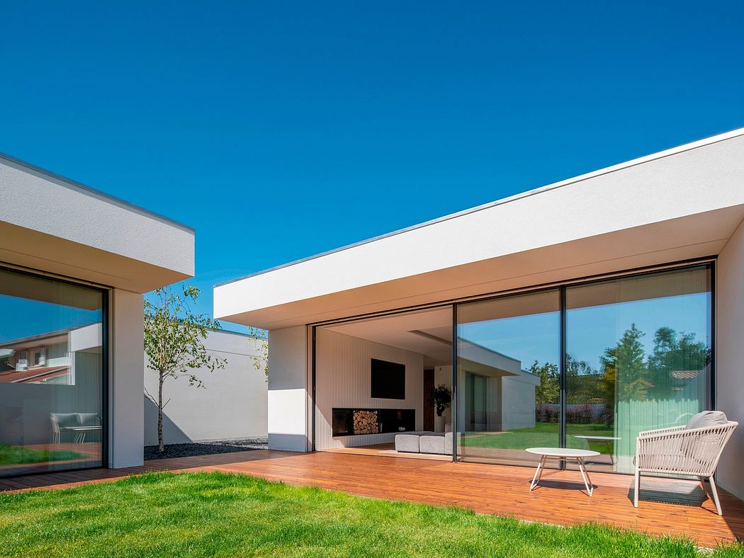 Modern house with large windows and an outdoor seating area.