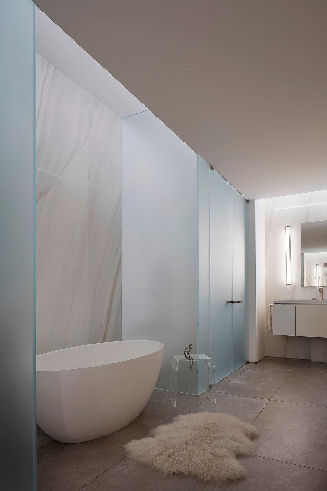 Modern bathroom with a freestanding tub and frosted glass partition.
