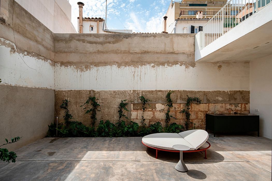 Modern outdoor patio with minimalist furniture and weathered walls.
