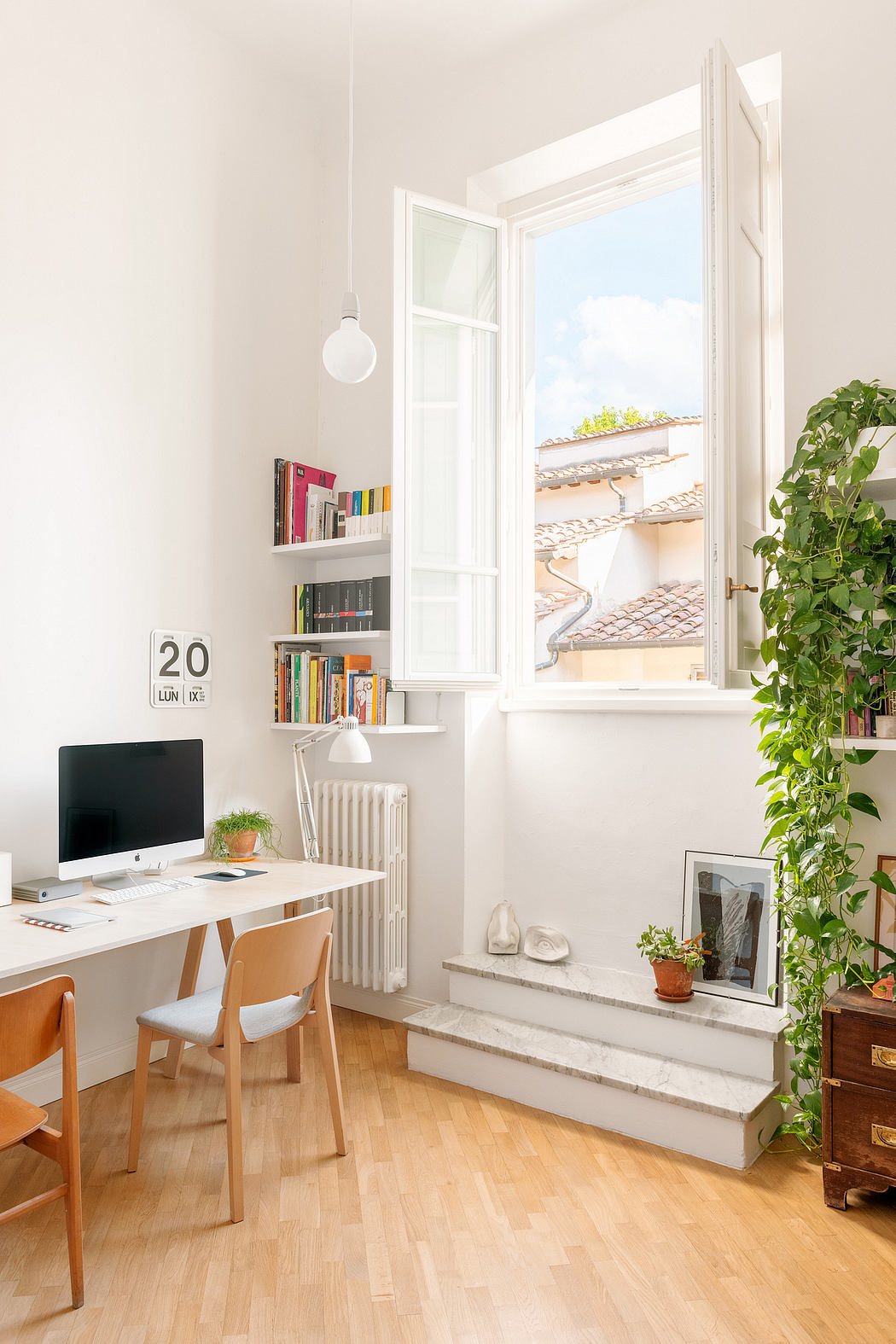 Bright home office with desk, computer, bookshelf, and window with a view