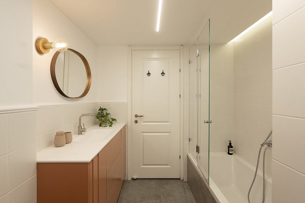 Modern bathroom with white walls, a shower, and a round mirror.