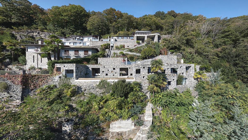 Stone buildings on a hillside with greenery around.