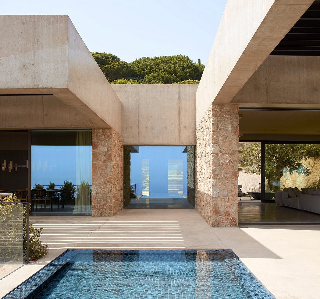 Modern house with concrete structure, glass doors, and a small pool.