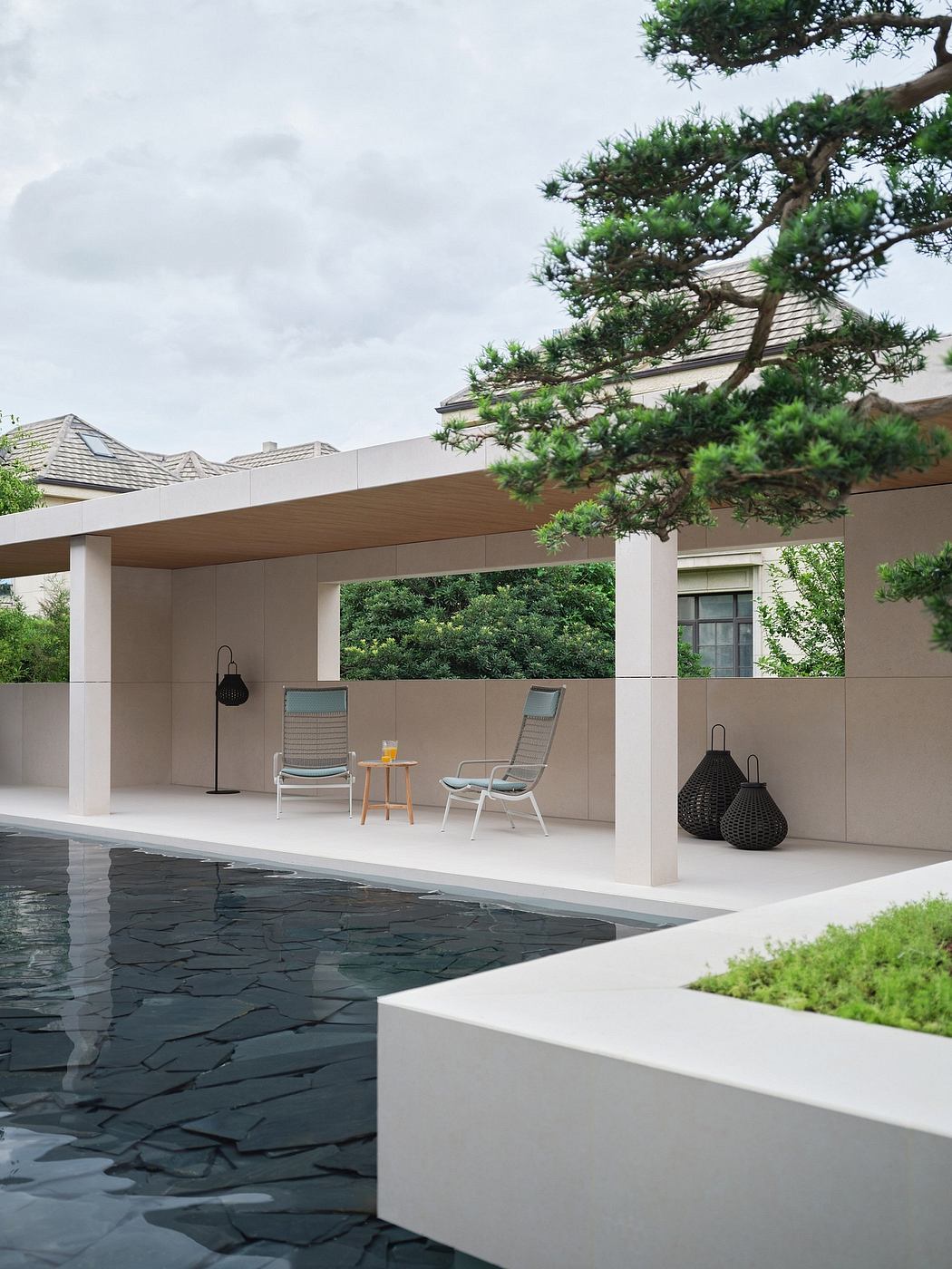 Sleek, modern poolside pavilion with minimalist furniture and lush greenery.