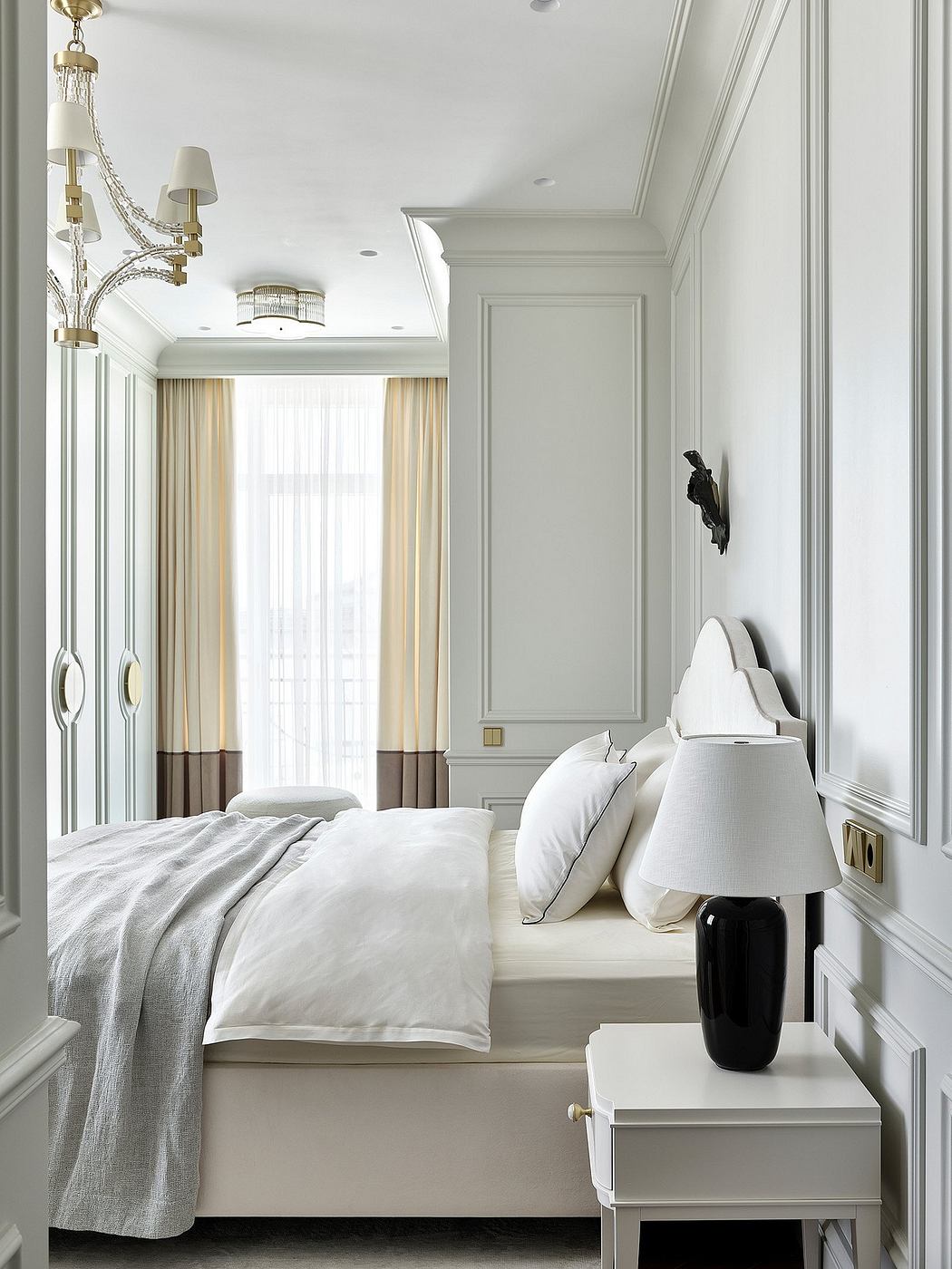 Elegant bedroom with crown molding, built-in cabinetry, and luxurious bedding.