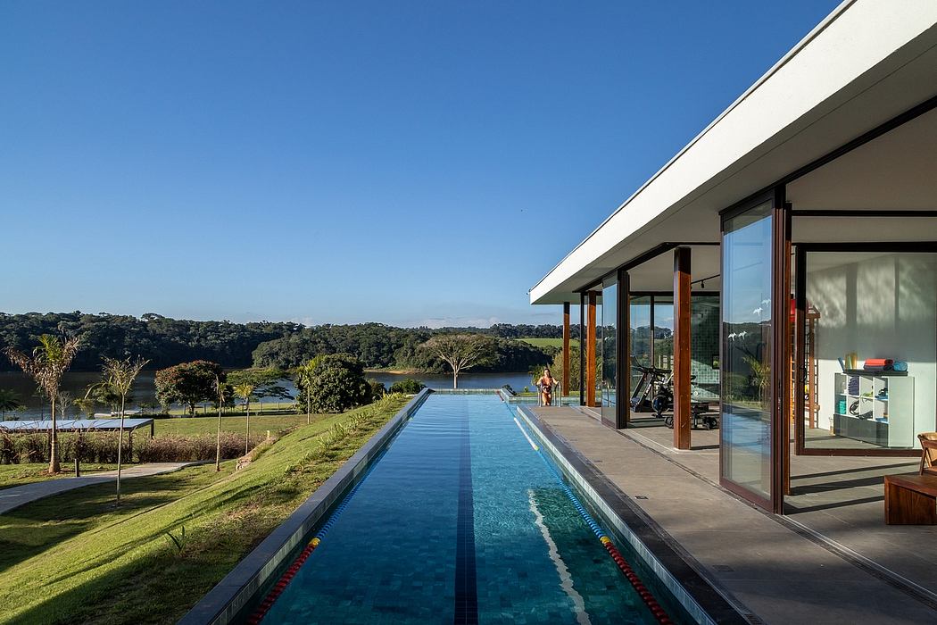 Sleek house with long pool overlooking scenic landscape.